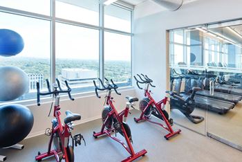 A gym with exercise bikes and a view of the city.